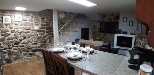 a kitchen with a table and a stone wall at A Casiña Vella in Poio