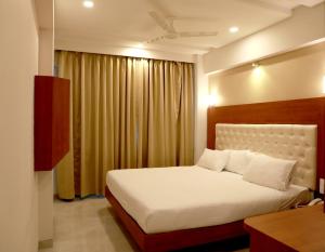 a bedroom with a large bed and a window at Hotel Lords, Fort in Mumbai