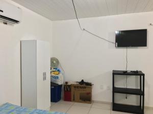 a room with a tv on the wall and a box at Flat Shopping Amarração N - 129 in Luis Correia