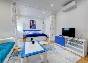 Un dormitorio con una cama azul y un televisor. en Apartments Best, en Mostar 10 fotos más