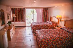 una camera d'albergo con due letti e un balcone di Heritage Hotel a Saint John's