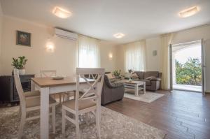 a living room with a table and chairs and a couch at Queen Teuta - Sea View - Private Parking & Garden - BBQ Grill in Risan