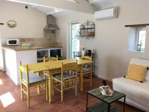 a kitchen with a yellow table and chairs in a living room at gite le cabanon in Réauville