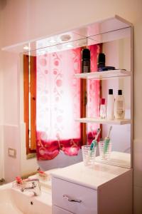 a bathroom with a sink and a mirror with toothbrushes at La Terrazza in Empoli