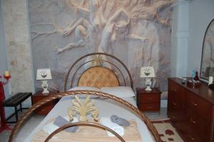 アスプロヴァルタにあるLuxury House Papadimitriouのベッドルーム1室(壁に絵画が描かれたベッド1台付)