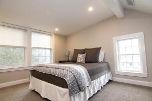 a bedroom with a bed and two windows at Two Bedroom with Lake View in Wolfeboro