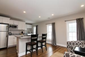 a kitchen with white cabinets and black chairs and a counter at Two Bedroom with Lake View in Wolfeboro