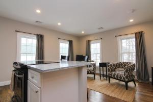 a kitchen with a counter and some chairs and windows at Two Bedroom with Lake View in Wolfeboro