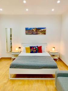 - une chambre avec un grand lit blanc et des oreillers colorés dans l'établissement Nea Loft, à Naples