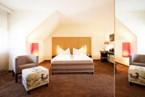pokój hotelowy z łóżkiem i krzesłem w obiekcie Hotel Nationalpark w mieście Illmitz