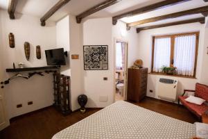 a bedroom with a bed and a tv in a room at La Casa In Pietra in Santa Caterina Villarmosa