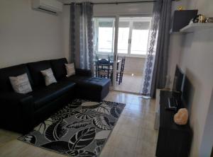 a living room with a black couch and a table at Mediterranean Bliss 317 in Cala de Finestrat
