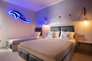 a bedroom with two beds with a neon sign on the wall at House Katerina Mediterranean in Sarti