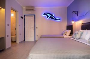 a bedroom with two beds with a dolphins sign on the wall at House Katerina Mediterranean in Sarti