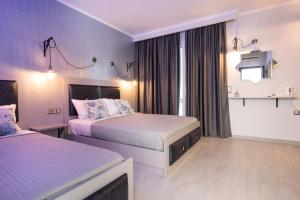 a hotel room with two beds with purple walls at House Katerina Mediterranean in Sarti