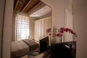una camera da letto con specchio, letto e televisore di Ci Holidays a La Spezia