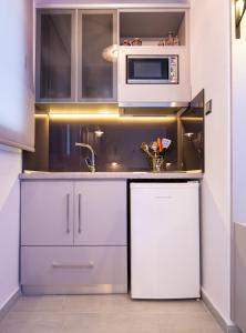 a kitchen with a microwave and a refrigerator at House Katerina Mediterranean in Sarti