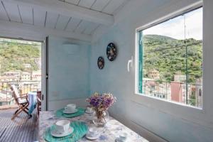 una sala da pranzo con tavolo e una grande finestra di Apt. with an exciting view a Monterosso al Mare