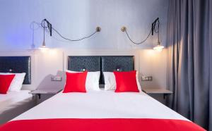 a bedroom with two red pillows on a large bed at House Katerina Mediterranean in Sarti