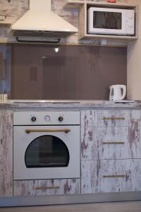 a kitchen with a stove and a microwave on a counter at House Katerina Mediterranean in Sarti