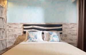 a bedroom with a bed with blue and white pillows at House Katerina Mediterranean in Sarti
