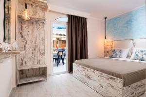 a hotel room with a bed and a balcony at House Katerina Mediterranean in Sarti