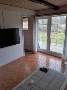 a living room with a flat screen tv on a wall at Törnholmen in Garnanäs