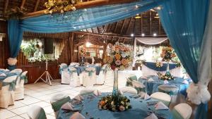 une salle de banquet avec des tables bleues et des chaises blanches dans l'établissement Hosteria Flor de Canela, à Puyo