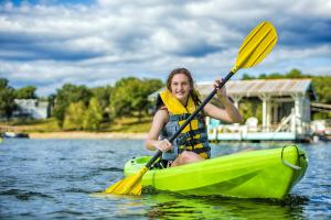 una mujer sentada en un kayak en el agua en Still Waters Resort en Branson