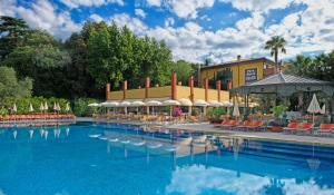 a large swimming pool with chairs and umbrellas at Parc Hotel Gritti in Bardolino