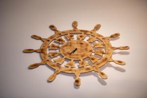a wooden sunburst clock on a white wall at House Katerina Mediterranean in Sarti