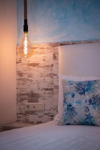 a bed with a pillow and a light above it at House Katerina Mediterranean in Sarti