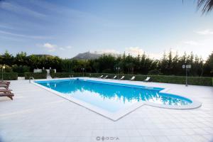 a swimming pool in a yard with chairs at Torre Venza in Valderice