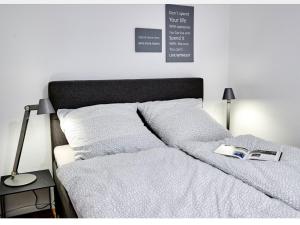 ein Bett mit weißer Bettwäsche und ein Buch darauf in der Unterkunft Grünstrand in Travemünde