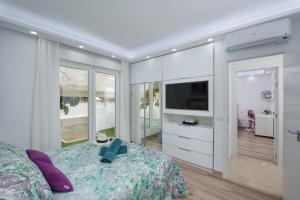 a bedroom with a bed and a flat screen tv at VILLA VALENTINA OCEAN VIEW HEATED Pool in Adeje +58 photos