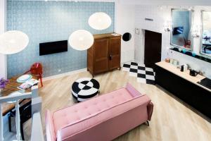 sala de estar con sofá rosa y cocina en Art Apartment en Cracovia