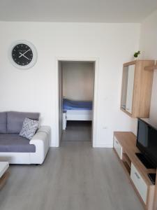 - un salon avec un canapé et un réveil sur le mur dans l'établissement Apartman Nekić, à Opatija
