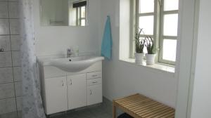 uma casa de banho branca com um lavatório e um espelho em Birkende Bed and Breakfast em Langeskov
