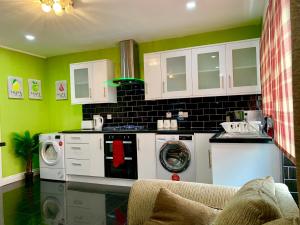 a kitchen with a washing machine and a washer at London 2 Bedroom Apartment, Kitchen, Reception and Private Garden in London