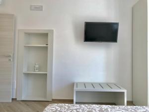 un soggiorno con TV su una parete bianca di Trifoglio Apartment a Maiori