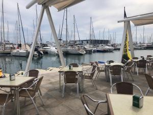 a patio with tables and chairs and boats in a marina at Piso Soballa, Centro y Playa in Santa Pola