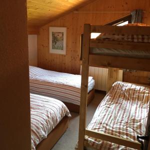 a bedroom with two bunk beds in a cabin at CHALET DES NEIGES in Les Carroz d'Araches