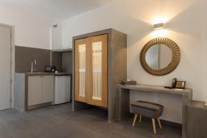 a bathroom with a vanity and a mirror and a sink at Elitoz Suites in Oia