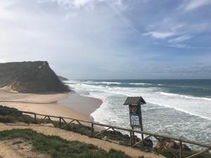 a sign next to a beach with the ocean at Casa Praia do Sul in Ericeira