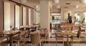 a dining room with wooden tables and chairs at Elefsina Hotel in Eleusis