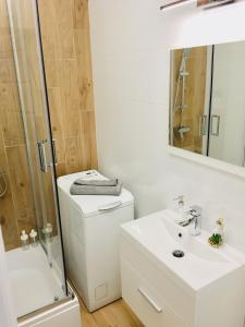 een badkamer met een toilet, een wastafel en een douche bij Andersena 190 B - 12 piętro - 10 min CMKP - 5 min Metro - 15 min Centrum in Warschau