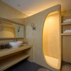 
a bathroom with a sink and a mirror at Elitoz Suites in Oia
