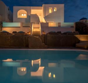 a villa with a swimming pool at night at Elitoz Suites in Oia