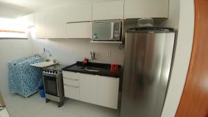 cocina con nevera de acero inoxidable y microondas en Condomínio Residencial Sossego na Beira do Rio, en Paulo Afonso