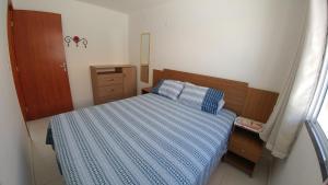 a small bedroom with a bed with a blue comforter at Condomínio Residencial Sossego na Beira do Rio in Paulo Afonso +9 photos